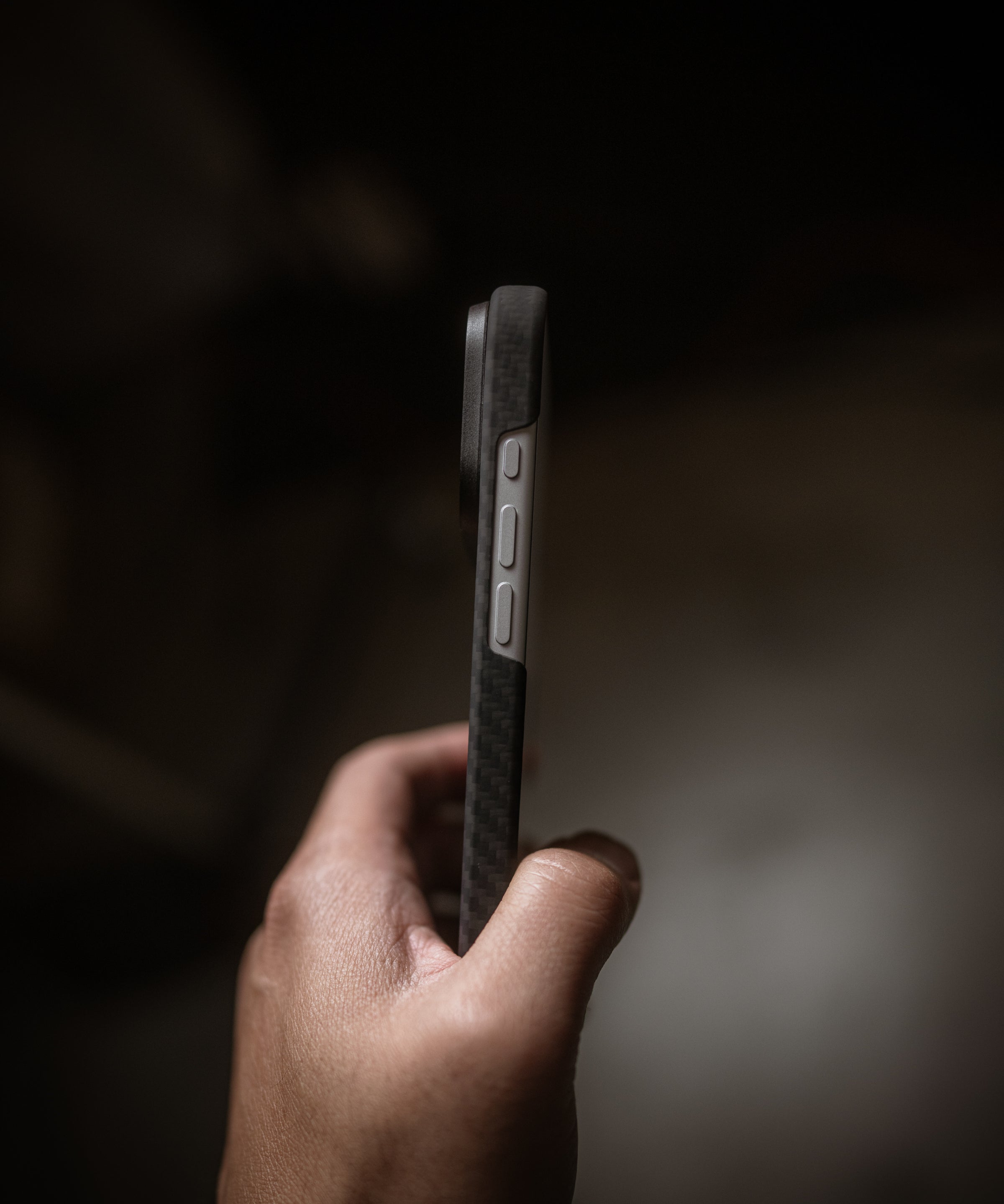carbon-fiber-iphone-17-pro-max-case-thin-profile-held in hand on a dark background