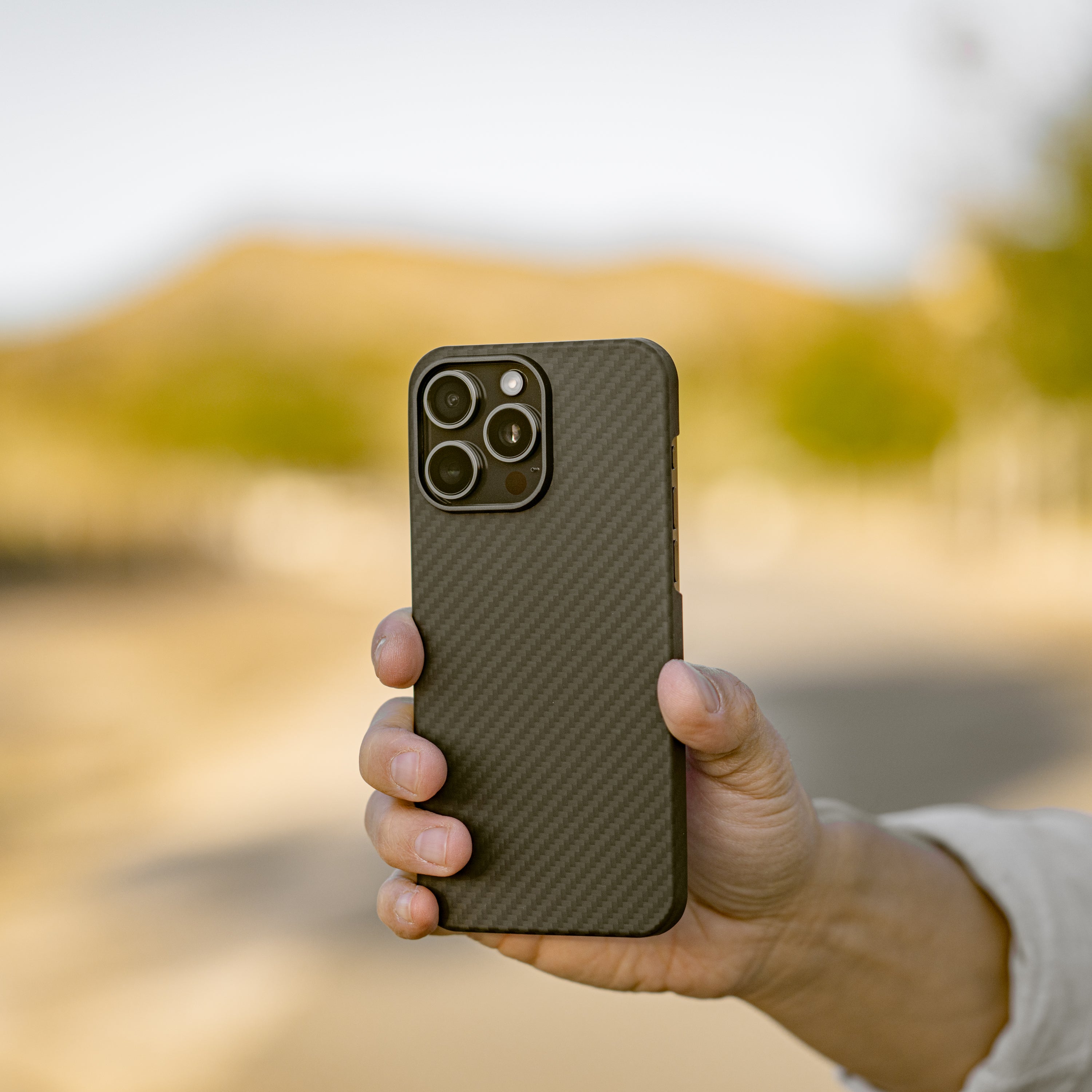 Mason aramid fiber iPhone case in matte black, held in hand, slim and lightweight